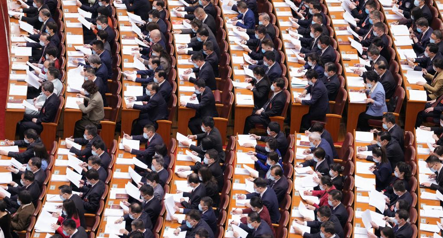 十四届全国人大一次会议在京开幕——代表们认真听会