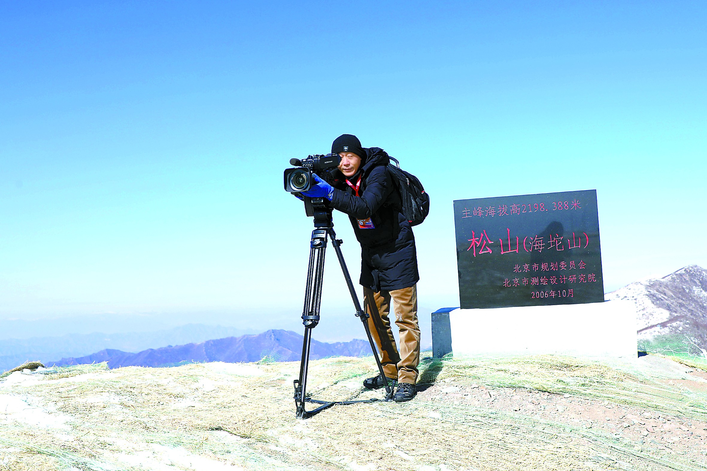 为参加北京冬奥会的摄影记者们寻找最佳拍摄位置的段学锋 “初心和使命要用脚步和坚守去书写”