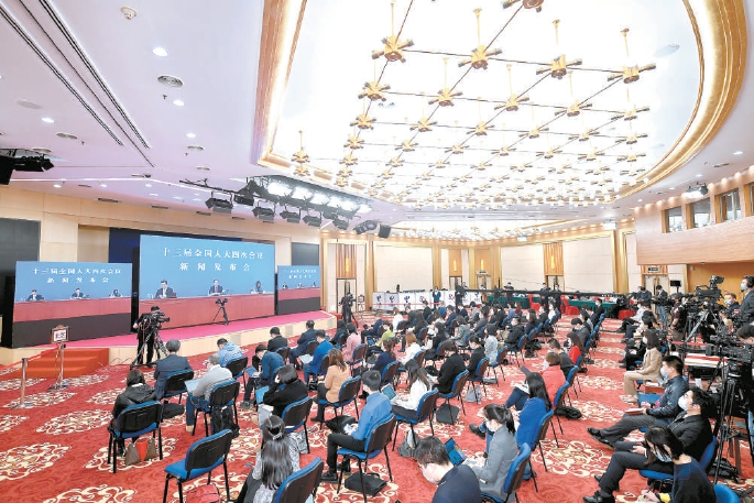 昨晚，十三届全国人大四次会议新闻发布会举行。图为记者在分会场采访。