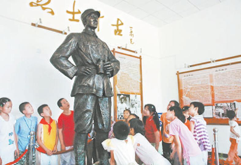 2011年，密云的小学生围着白乙化烈士的雕像听辅导员讲述抗战英雄的革命事迹。